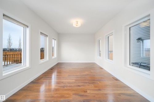 Unfurnished sunroom featuring wood finished floors and plenty of natural light - 19743 26 Avenue, Edmonton, AB - Indoor Photo Showing Other Room