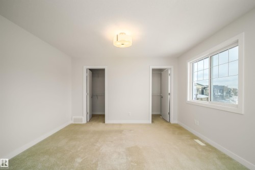 Unfurnished bedroom featuring two closets and light carpet - 19743 26 Avenue, Edmonton, AB - Indoor Photo Showing Other Room