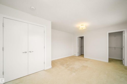 Unfurnished bedroom featuring carpet flooring and two closets - 19743 26 Avenue, Edmonton, AB - Indoor Photo Showing Other Room