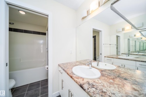 Bathroom with vanity, dark tile patterned floors, and shower / washtub combination - 19743 26 Avenue, Edmonton, AB - Indoor Photo Showing Bathroom