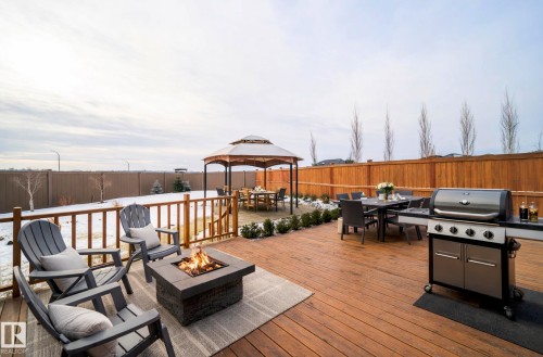 Wooden deck featuring outdoor dining space, a gazebo, a grill, a patio, and a fenced backyard - 19743 26 Avenue, Edmonton, AB - Outdoor With Deck Patio Veranda