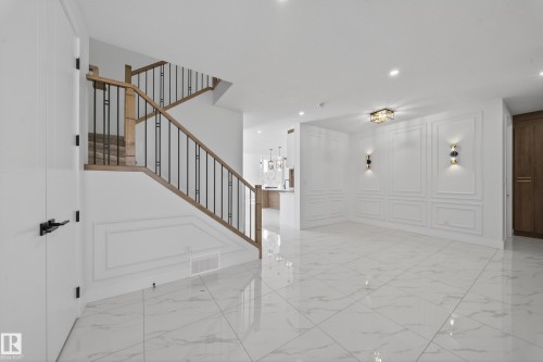 Stairway with a decorative wall, marble finish flooring, and recessed lighting - 4006 40 Street, Beaumont, AB - Indoor Photo Showing Other Room