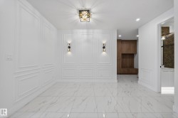 Foyer entrance featuring a decorative wall, light marble finish floors, recessed lighting, and a wainscoted wall - 