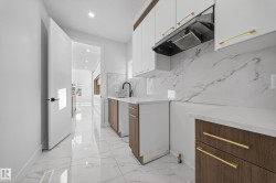 Dual tone kitchen featuring dual tone cabinetry, recessed lighting, light marble finish floors, light stone countertops, and modern cabinets - 