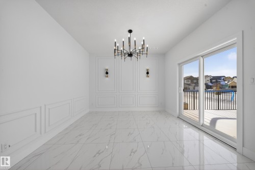 Unfurnished dining area with a decorative wall, hanging lights, and light marble finish flooring - 4006 40 Street, Beaumont, AB - Indoor Photo Showing Other Room