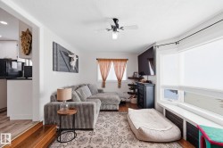 Living area with wood finished floors and ceiling fan - 