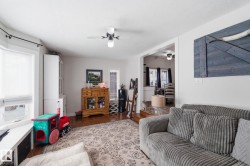 Living room featuring wood finished floors and ceiling fan - 