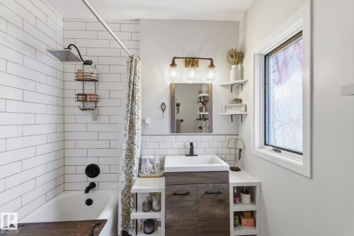 Full bathroom featuring vanity, shower / tub combo, and backsplash - 4919 50 Avenue, Bon Accord, AB - Indoor Photo Showing Bathroom