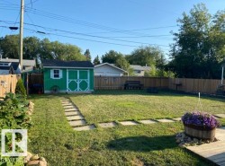 Fenced backyard featuring a storage shed - 