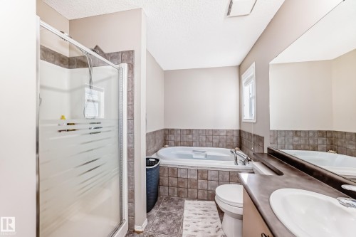 Full bathroom with vanity, a shower stall, a textured ceiling, a bath, and tile patterned floors - 14043 151 Avenue, Edmonton, AB - Indoor Photo Showing Bathroom