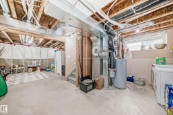 Below grade area featuring water heater, washing machine and clothes dryer, and heating unit - 