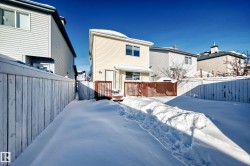 Snow covered house with a fenced backyard and a deck - 