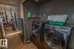 Laundry area featuring light wood finished floors and washing machine and clothes dryer - 