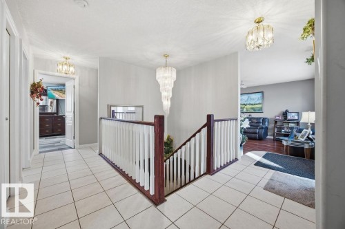 Corridor featuring suspended lighting, an upstairs landing, and light tile patterned floors - 3011 44A Street, Edmonton, AB - Indoor Photo Showing Other Room