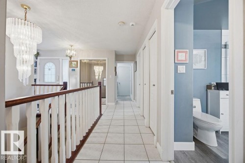 Hall with hanging lights and light tile patterned floors - 3011 44A Street, Edmonton, AB - Indoor Photo Showing Other Room