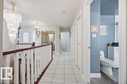 Hall with hanging lights and light tile patterned floors - 