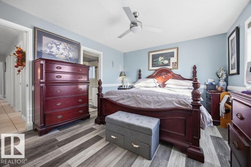 Bedroom with a ceiling fan, wood finished floors, and ensuite bath - 3011 44A Street, Edmonton, AB - Indoor Photo Showing Bedroom