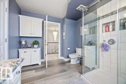Bathroom with vanity, a stall shower, and light wood-type flooring - 