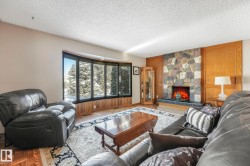 Living room featuring parquet floors, a fireplace, and a textured ceiling - 