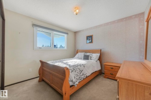 Bedroom featuring light carpet and a textured ceiling - 760 Knottwood Road S, Edmonton, AB - Indoor Photo Showing Bedroom
