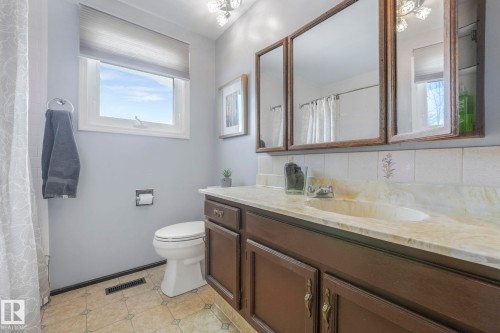 Full bathroom with vanity, a shower with curtain, tasteful backsplash, and a chandelier - 760 Knottwood Road S, Edmonton, AB - Indoor Photo Showing Bathroom