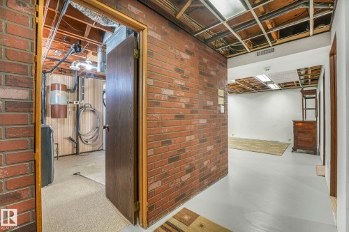 Below grade area featuring brick wall and washer / clothes dryer - 760 Knottwood Road S, Edmonton, AB - Indoor Photo Showing Other Room
