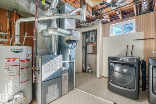 Utilities featuring water heater, heating unit, and independent washer and dryer - 760 Knottwood Road S, Edmonton, AB - Indoor Photo Showing Laundry Room