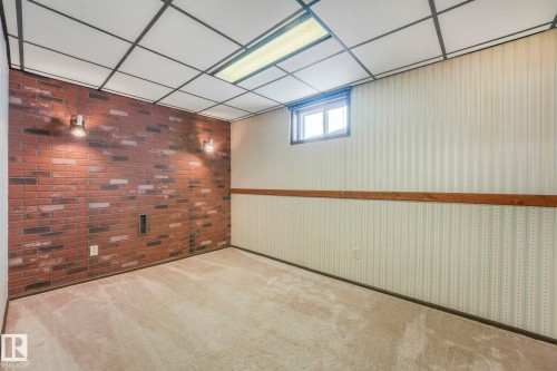 Below grade area featuring carpet, brick wall, and a drop ceiling - 760 Knottwood Road S, Edmonton, AB - Indoor Photo Showing Other Room