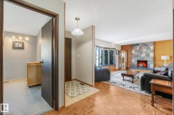 Living room with a textured ceiling, parquet flooring, a fireplace, and wood walls - 