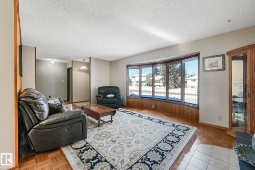 Living room featuring a textured ceiling and parquet floors - 760 Knottwood Road S, Edmonton, AB - Indoor