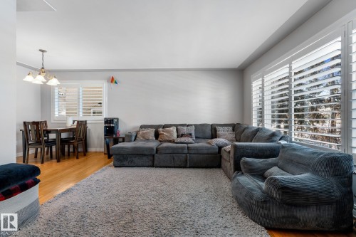 Living room featuring light wood-style floors and hanging lights - 9847 79 Street, Edmonton, AB - Indoor Photo Showing Living Room
