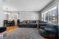 Living room featuring light wood-style floors and hanging lights - 