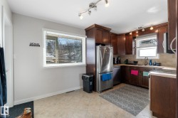 Kitchen featuring stainless steel appliances, dark wood finish cabinets, light countertops, and tasteful backsplash - 