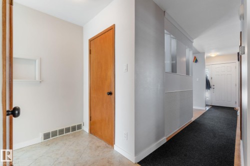 Corridor with baseboards and light tile patterned floors - 9847 79 Street, Edmonton, AB - Indoor Photo Showing Other Room