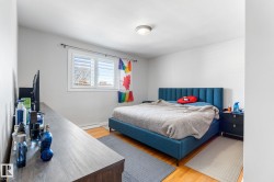 Bedroom with wood finished floors and a baseboard heating unit - 