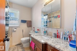 Full bathroom with a shower with shower curtain, vanity, tasteful backsplash, and light tile patterned floors - 