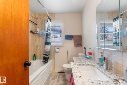 Bathroom featuring vanity, shower / bath combination with curtain, and backsplash - 9847 79 Street, Edmonton, AB - Indoor Photo Showing Bathroom
