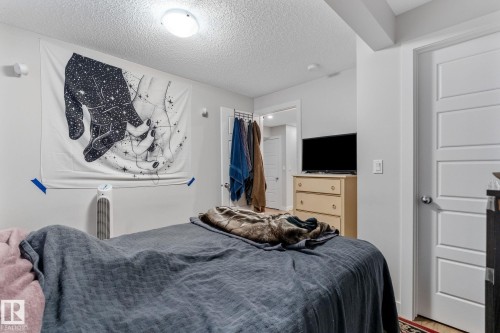 Bedroom featuring a textured ceiling and wood finished floors - 9847 79 Street, Edmonton, AB - Indoor Photo Showing Bedroom