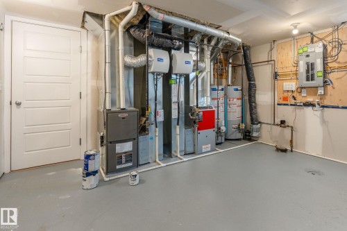 Utilities featuring electric panel, gas water heater, and heating unit - 9847 79 Street, Edmonton, AB - Indoor
