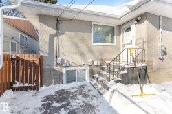 Snow covered property entrance featuring stucco siding - 