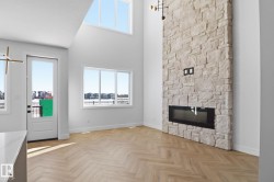 Unfurnished living room featuring a high ceiling, parquet floors, and a fireplace - 