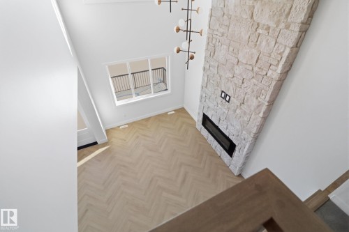 Unfurnished living room featuring a fireplace, a high ceiling, and parquet floors - 90 Eldridge Point(E), St. Albert, AB - Indoor Photo Showing Other Room