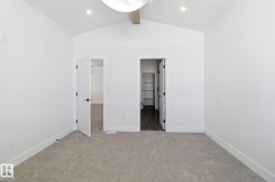 Unfurnished bedroom featuring light colored carpet, a walk in closet, and recessed lighting - 