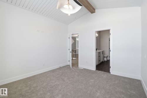 Unfurnished bedroom with dark colored carpet, connected bathroom, a ceiling fan, and a high wood beamed ceiling - 90 Eldridge Point(E), St. Albert, AB - Indoor Photo Showing Other Room