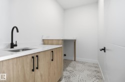 Laundry room featuring a sink and light tile patterned floors - 