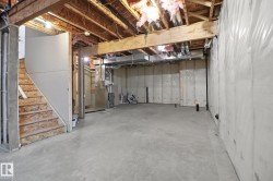 Unfinished below grade area featuring stairway and heating unit - 