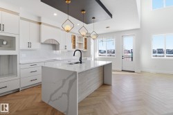 Kitchen featuring backsplash, hanging light fixtures, parquet floors, white cabinets, and glass insert cabinets - 