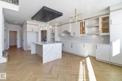 Kitchen with white cabinetry, a kitchen island with sink, backsplash, pendant lighting, and parquet flooring - 