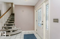 Entryway featuring a textured ceiling and light tile patterned floors - 