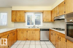 Kitchen featuring stainless steel appliances, tile countertops, tasteful backsplash, and light tile patterned floors - 